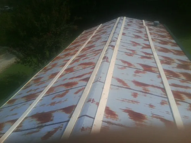 Rusted metal roof panels with new wood purlins before replacement — Storm Damage Roof Repair in Crisfield by Roofing Brothers