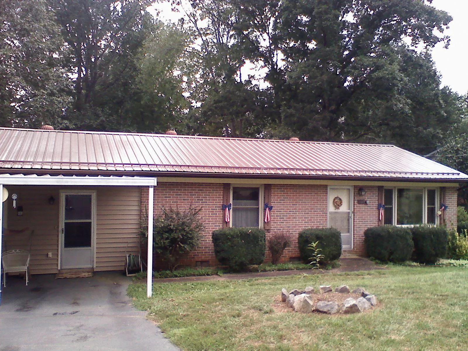 Bronze metal roof and carport on a brick ranch home — Roof Repair work by our crew in Crisfield